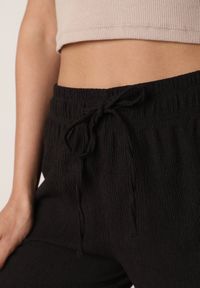 Born2be - Czarne Szerokie Spodnie z Teksturalnej Tkaniny z Wiązaniem w Pasie Agatia. Okazja: do pracy, na co dzień, na spacer. Stan: podwyższony. Kolor: czarny. Materiał: tkanina. Długość: długie. Styl: wakacyjny, casual #3