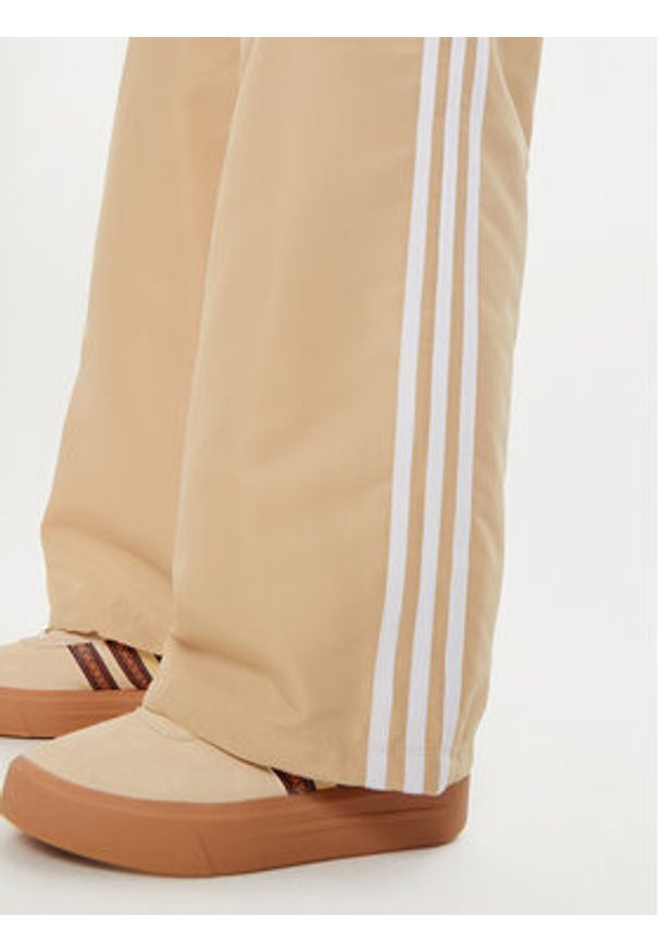 Adidas - adidas Spodnie dresowe adicolor 3-Stripes IZ0717 Beżowy Loose Fit. Kolor: beżowy. Materiał: syntetyk