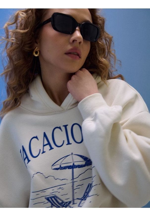 Sinsay - Dresowa bluza hoodie z nadrukiem "Vacaciones" - kremowy. Kolor: kremowy. Materiał: dresówka. Wzór: nadruk