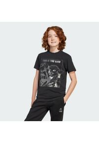 Koszulka Adidas Star Wars Mandalorian Graphic. Kolor: czarny, szary, wielokolorowy. Materiał: bawełna. Wzór: motyw z bajki. Sport: joga i pilates