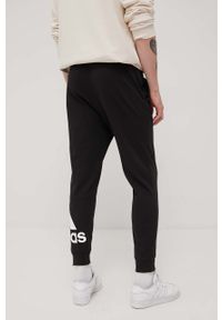 Adidas - adidas spodnie męskie kolor czarny z nadrukiem. Kolor: czarny. Materiał: materiał, poliester, bawełna. Wzór: nadruk
