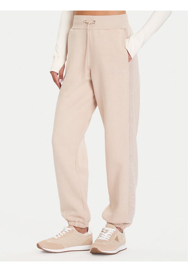 Guess Spodnie dresowe V5BB10 KB681 Beżowy Regular Fit. Kolor: beżowy. Materiał: bawełna, syntetyk