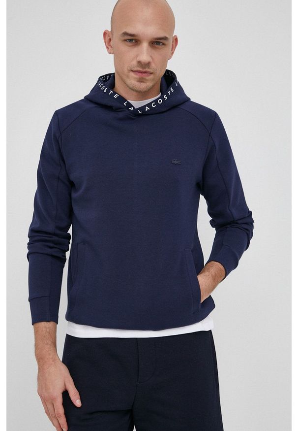 Lacoste Bluza męska kolor granatowy z kapturem gładka. Okazja: na co dzień. Typ kołnierza: kaptur. Kolor: niebieski. Materiał: dzianina. Wzór: gładki. Styl: casual