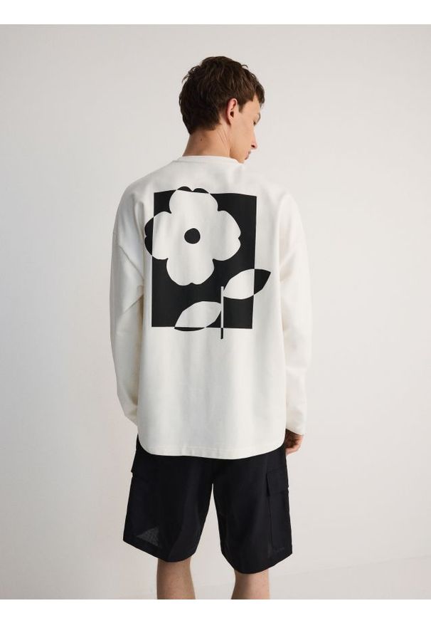 Reserved - Longsleeve oversize z nadrukiem - złamana biel. Materiał: bawełna, dzianina. Długość rękawa: długi rękaw. Wzór: nadruk