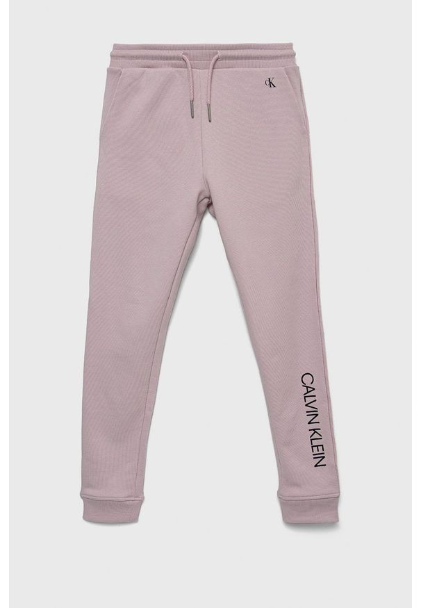 Calvin Klein Jeans spodnie dresowe bawełniane dziecięce kolor różowy z nadrukiem. Kolor: różowy. Materiał: bawełna, dresówka. Wzór: nadruk