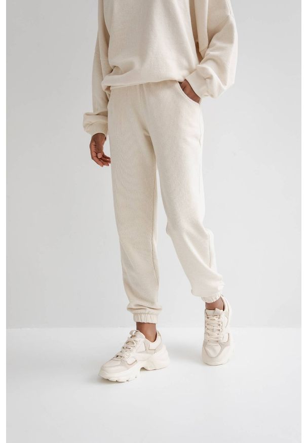 Marsala - Spodnie dresowe typu jogger w kolorze BRIGHT BEIGE ze strukturalnej dzianiny - DISPLAY. Stan: podwyższony. Materiał: dresówka, dzianina. Styl: elegancki