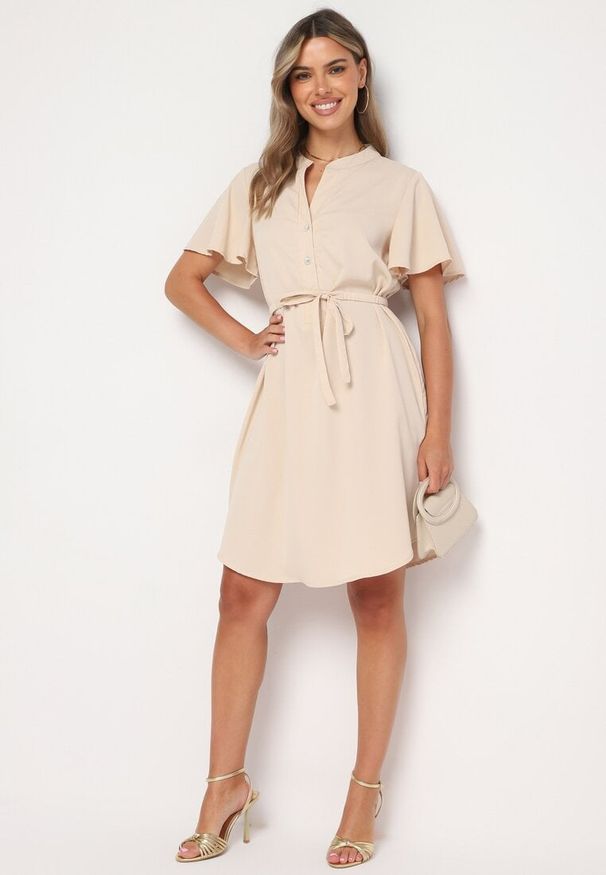 Born2be - Beżowa Sukienka Trapezowa z Koszulową Górą i Materiałowym Paskiem w Talii Vikiiona. Okazja: na spotkanie biznesowe. Typ kołnierza: dekolt w kształcie V. Kolor: beżowy. Materiał: materiał. Długość rękawa: krótki rękaw. Typ sukienki: koszulowe, trapezowe. Styl: biznesowy