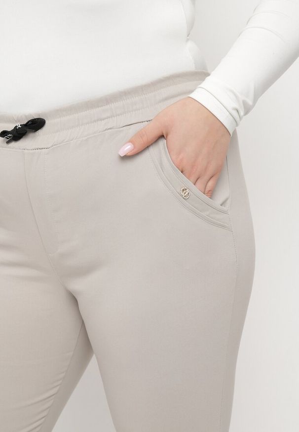 Born2be - Jasnobeżowe Spodnie z Nogawkami 7/8 i Kieszeniami Gavotta. Okazja: na co dzień. Kolekcja: plus size. Kolor: beżowy. Materiał: satyna. Styl: elegancki, casual