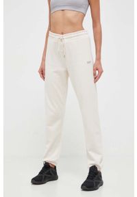 DKNY - Dkny spodnie dresowe kolor beżowy gładkie. Kolor: beżowy. Materiał: dresówka. Wzór: gładki