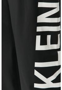 Calvin Klein Jeans - Spodnie. Kolor: czarny. Materiał: tkanina, poliamid, elastan. Wzór: nadruk #2