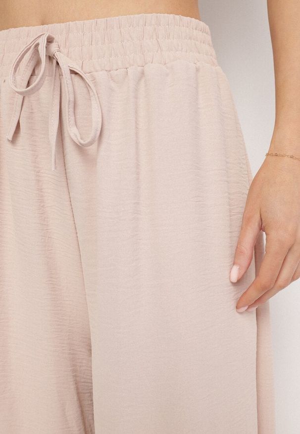 Born2be - Beżowe Szerokie Spodnie Typu Palazzo z Wiązaniem Ulialitia. Okazja: na co dzień. Stan: podwyższony. Kolor: beżowy. Styl: casual, elegancki