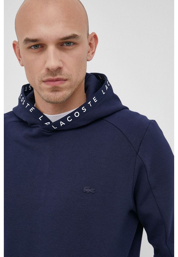 Lacoste Bluza męska kolor granatowy z kapturem gładka. Okazja: na co dzień. Typ kołnierza: kaptur. Kolor: niebieski. Materiał: dzianina. Wzór: gładki. Styl: casual