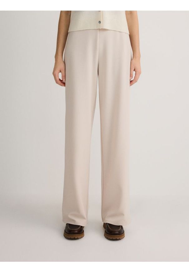 Reserved - Spodnie z szerokimi nogawkami - beżowy. Kolor: beżowy. Materiał: tkanina. Wzór: gładki
