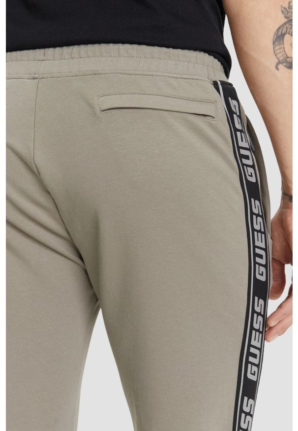 Guess - GUESS Zielone męskie spodnie dresowe z lampasami New Arlo, Rozmiar S. Kolor: zielony. Materiał: dresówka