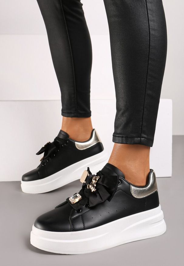 Renee - Czarno-Złote Sneakersy na Platformie Ozdobione Aplikacją i Kokardą Rorinia. Nosek buta: okrągły. Zapięcie: sznurówki. Kolor: czarny. Materiał: materiał. Wzór: aplikacja. Obcas: na platformie. Wysokość obcasa: niski