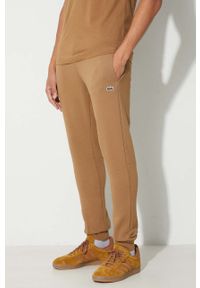 Lacoste spodnie dresowe męskie kolor brązowy gładkie. Kolor: brązowy. Materiał: dresówka. Wzór: gładki