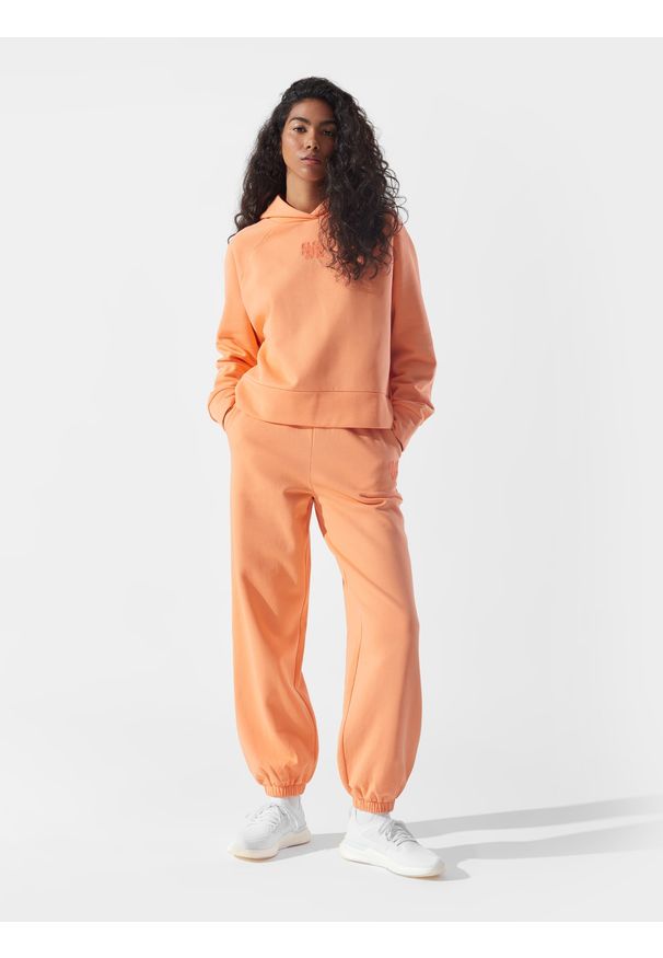 4f - Spodnie dresowe joggery z bawełną organiczną damskie 4F x Anna Lewandowska. Stan: podwyższony. Kolor: pomarańczowy. Materiał: bawełna, dresówka. Wzór: nadruk. Sport: fitness