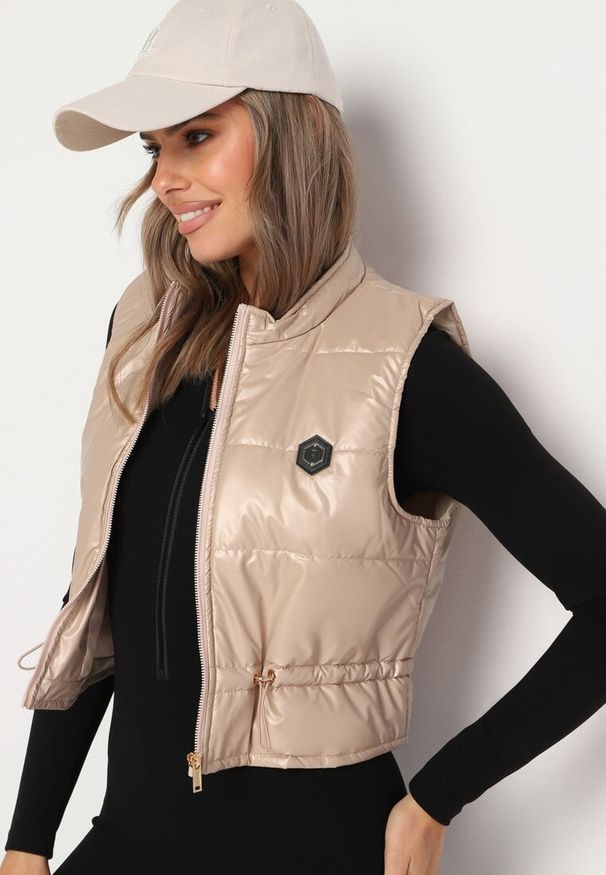 Born2be - Beżowa Krótka Kamizelka Ozdobiona Naszywką Ściągana w Talii Mevelina. Kolor: beżowy. Długość: krótkie. Wzór: aplikacja. Styl: elegancki