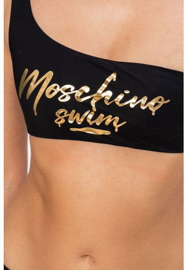 MOSCHINO Asymetryczna góra od bikini ze złotym logo. Kolor: czarny. Wzór: nadruk