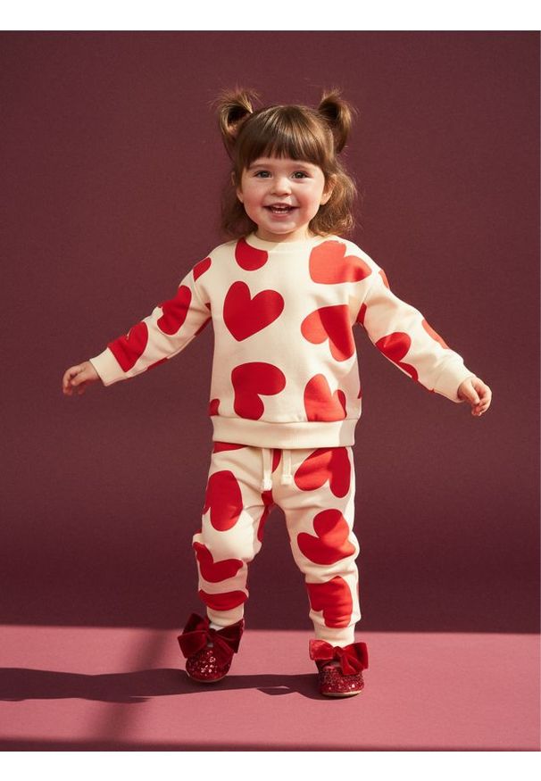 Sinsay - Spodnie dresowe jogger ze wzorem w serca - kremowy. Kolor: kremowy. Materiał: dresówka