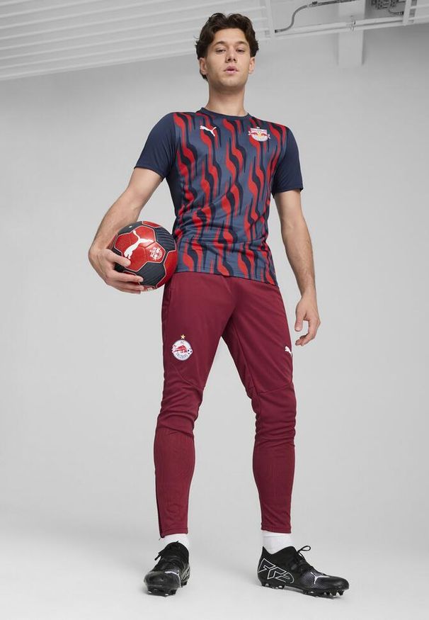 Puma - Męska koszulka przedmeczowa z krótkim rękawem FC Red Bull Salzburg PUMA. Kolor: czerwony, wielokolorowy, niebieski. Długość rękawa: krótki rękaw. Długość: krótkie