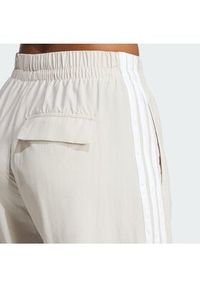 Adidas - adidas Spodnie dresowe Essentials 3-Stripes JC8168 Beżowy Loose Fit. Kolor: beżowy. Materiał: syntetyk #6