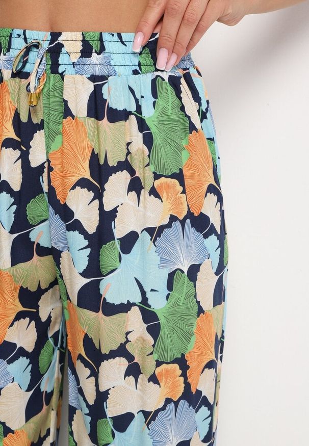 Born2be - Granatowe Kwiatowe Wiskozowe Spodnie o Szerokim Kroju z Wysokim Stanem i Gumką w Pasie Cenonea. Okazja: na co dzień. Stan: podwyższony. Kolor: niebieski. Materiał: wiskoza. Wzór: kwiaty. Styl: elegancki, casual