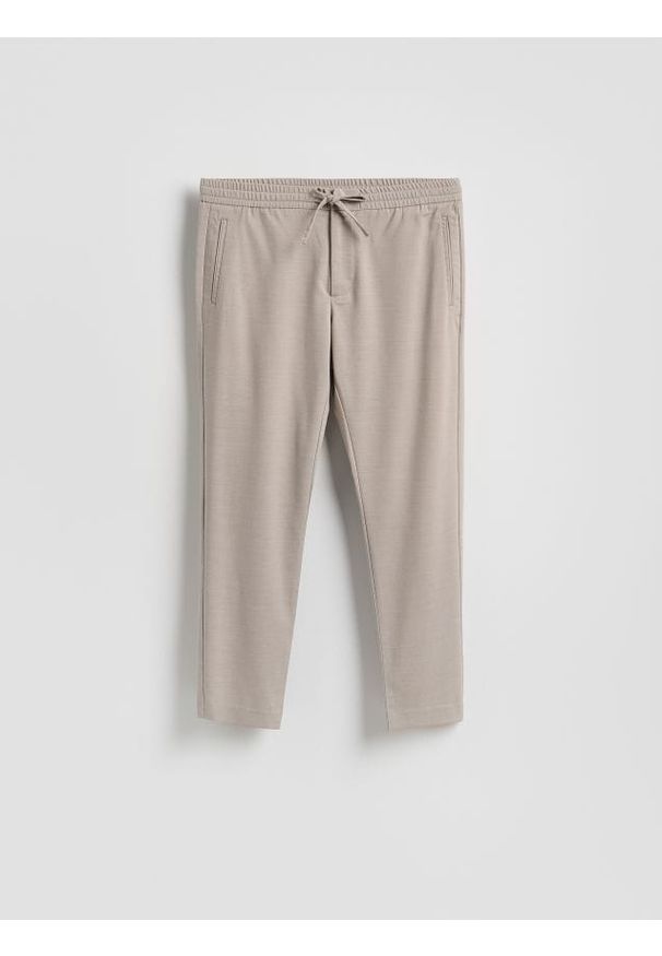 Reserved - Spodnie joggery - beżowy. Kolor: beżowy. Materiał: tkanina, wiskoza