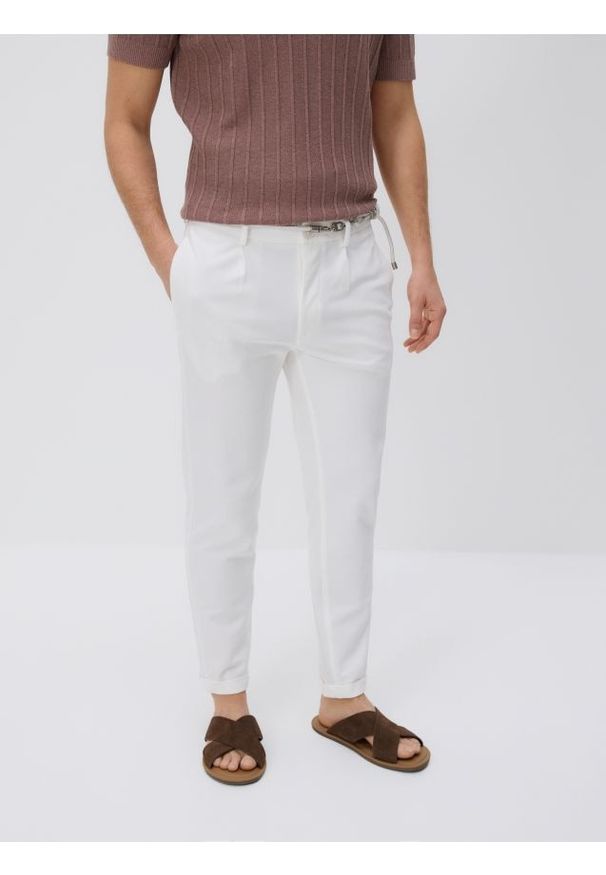 Reserved - Spodnie slim fit z paskiem - złamana biel. Materiał: dzianina, bawełna