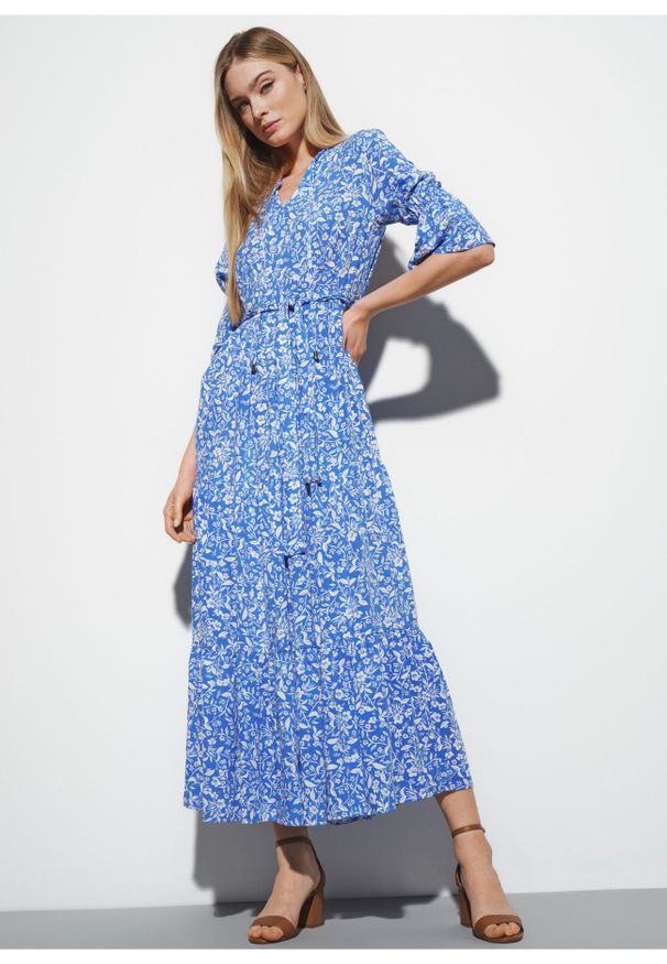 Ochnik - Długa niebieska sukienka w kwiaty. Kolor: niebieski. Materiał: wiskoza. Długość rękawa: krótki rękaw. Wzór: kwiaty. Długość: maxi