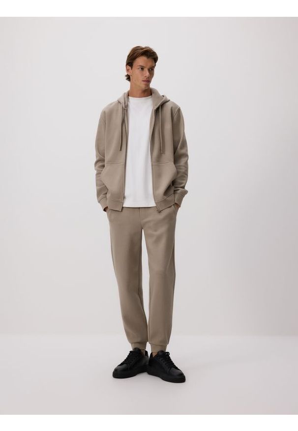 Reserved - Dresowe spodnie jogger z bawełną - brązowy. Kolor: brązowy. Materiał: bawełna, dresówka