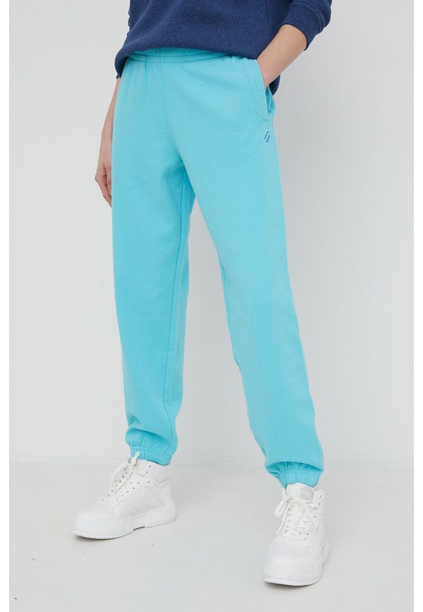 Superdry spodnie dresowe bawełniane damskie gładkie. Stan: podwyższony. Kolor: niebieski. Materiał: bawełna, dresówka. Wzór: gładki