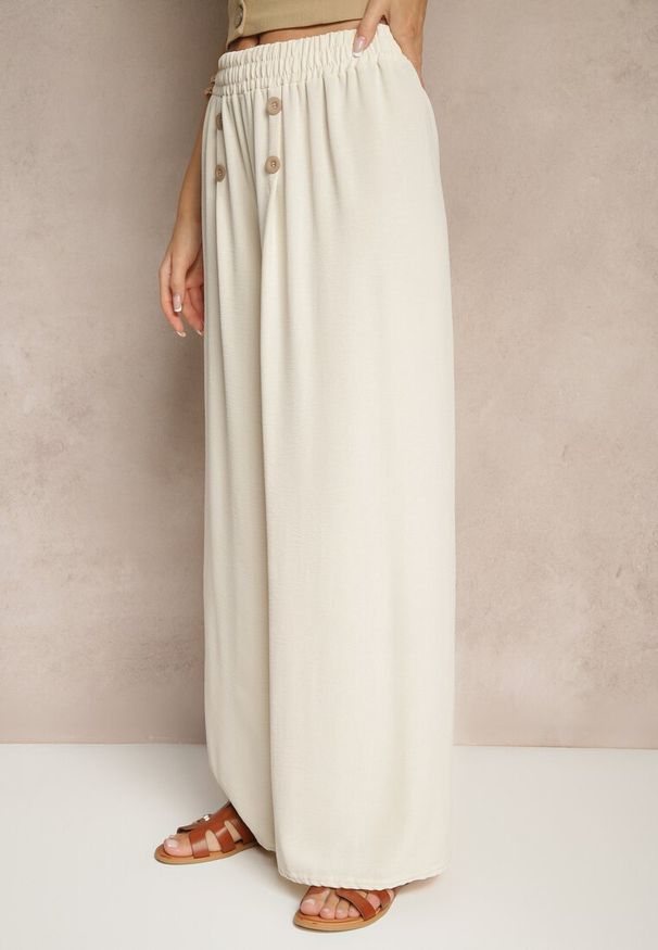 Renee - Jasnobeżowe Spodnie z Bawełną o Szerokim Kroju High Waist Ozdobione Guzikami Morritia. Okazja: na co dzień. Stan: podwyższony. Kolor: beżowy. Materiał: bawełna. Wzór: aplikacja. Styl: casual, elegancki