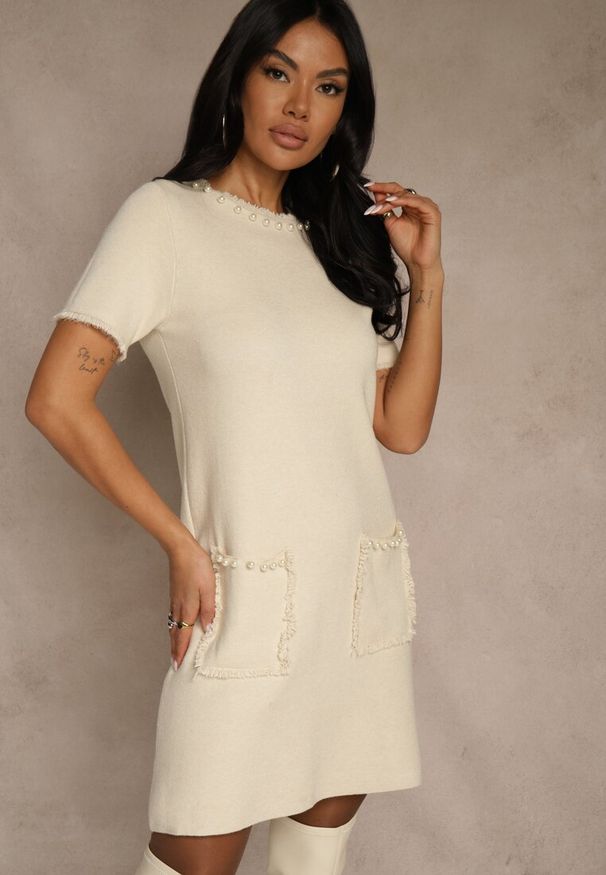 Renee - Jasnobeżowa Sweterkowa Sukienka Trapezowa z Perełkami przy Dekolcie i Kieszeniach Fenatusa. Okazja: na co dzień. Kolor: beżowy. Materiał: jeans. Typ sukienki: trapezowe. Styl: casual