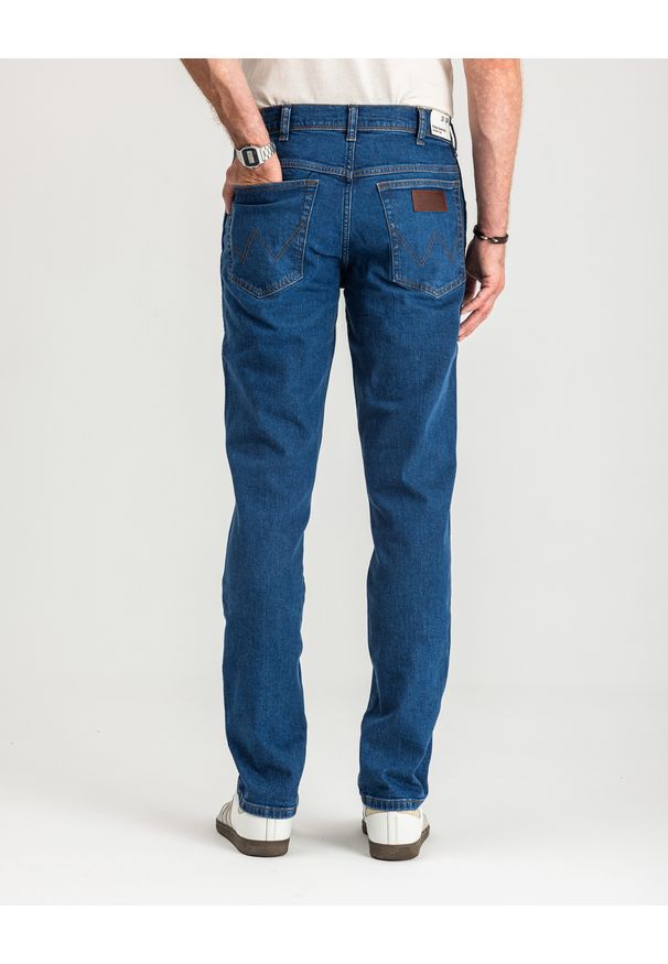 Wrangler - MĘSKIE SPODNIE JEANSOWE WRANGLER TEXAS SLIM GAME ON W12ST112E 112126517. Długość: krótkie. Wzór: napisy, aplikacja, jednolity. Sezon: lato. Styl: retro, klasyczny