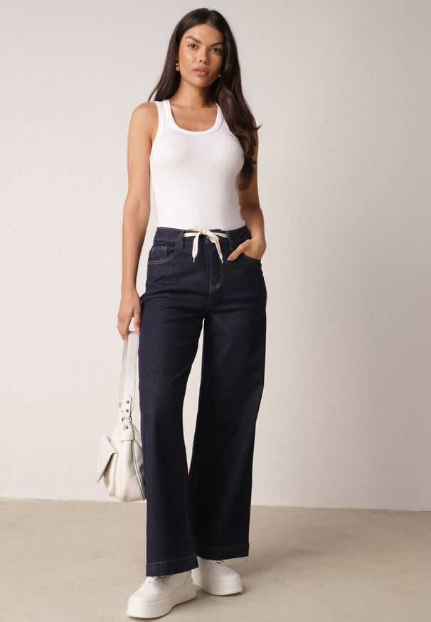 Born2be - Niebieskie Bawełniane Szerokie Jeansy z Wysokim Stanem Ozdobione Wiązaniem Lilinieth. Okazja: na co dzień. Stan: podwyższony. Kolor: niebieski. Wzór: aplikacja. Styl: casual, klasyczny