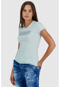 Guess - GUESS Błękitny t-shirt damski z metalicznym logo i cyrkoniami. Typ kołnierza: dekolt w serek. Kolor: niebieski. Materiał: bawełna