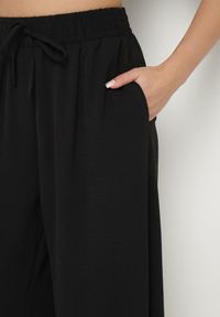 Born2be - Czarne Szerokie Spodnie Typu Palazzo z Wiązaniem Ulialitia. Okazja: na co dzień. Stan: podwyższony. Kolor: czarny. Styl: elegancki, casual #6