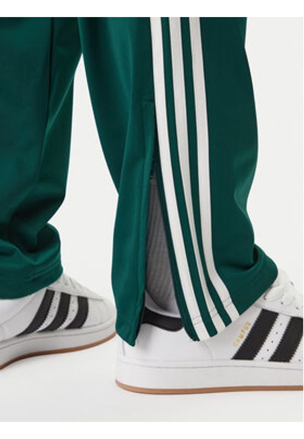 Adidas - adidas Spodnie dresowe Firebird KD8317 Zielony Loose Fit. Kolor: zielony. Materiał: syntetyk
