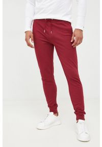 TOMMY HILFIGER - Tommy Hilfiger spodnie dresowe męskie kolor bordowy gładkie. Kolor: czerwony. Materiał: dresówka. Wzór: gładki #1