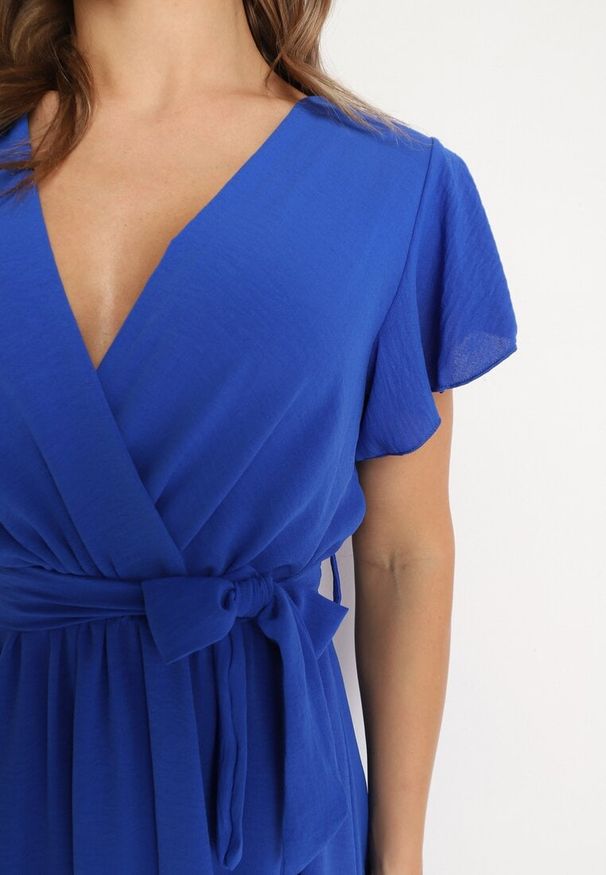 Born2be - Granatowa Kopertowa Sukienka z Asymetrycznym Dołem Ozdobiona Falbanką z Paskiem w Talii Snidia. Okazja: na co dzień, na spacer. Kolor: niebieski. Wzór: aplikacja. Sezon: lato. Typ sukienki: asymetryczne, kopertowe. Styl: elegancki, klasyczny, casual