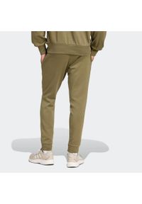 Adidas - Spodnie dresowe męskie ADIDAS Essentials Feelcozy. Kolor: zielony. Materiał: dresówka. Sport: joga i pilates