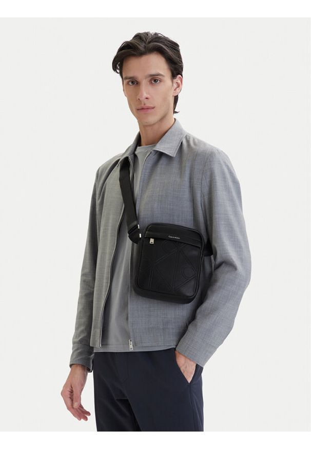 Calvin Klein Saszetka Emblem Aop Emboss Reporter LV04D3331G Czarny. Kolor: czarny. Materiał: skóra