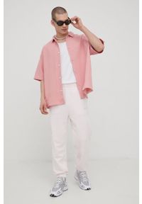Champion spodnie 217404 kolor różowy z aplikacją. Kolor: różowy. Materiał: włókno, dzianina, materiał. Wzór: aplikacja #4