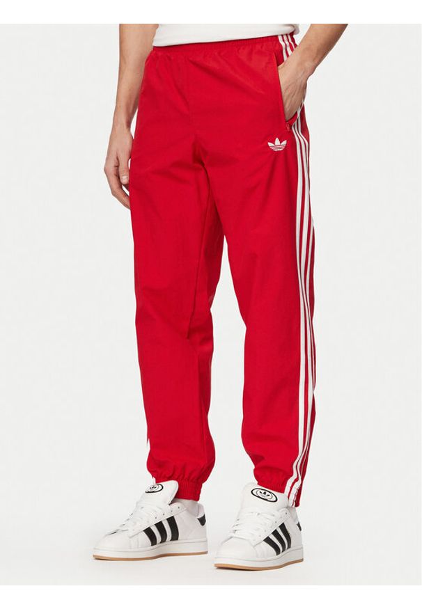 Adidas - adidas Spodnie dresowe Firebird Woven KE1369 Czerwony Regular Fit. Kolor: czerwony. Materiał: syntetyk