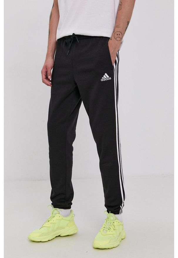 Adidas - adidas Spodnie męskie kolor czarny z aplikacją. Kolor: czarny. Materiał: materiał, bawełna, dzianina. Wzór: aplikacja