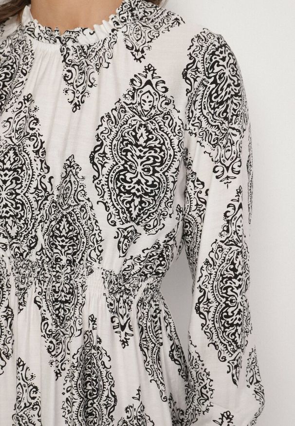 Born2be - Biała Sukienka o Rozkloszowanym Kroju z Gumką w Talii w Etniczny Wzór Napisa. Okazja: do pracy, na co dzień. Typ kołnierza: kołnierzyk stójkowy, kołnierz z falbankami. Kolor: biały. Materiał: skóra. Długość rękawa: długi rękaw. Wzór: aplikacja. Styl: elegancki, casual