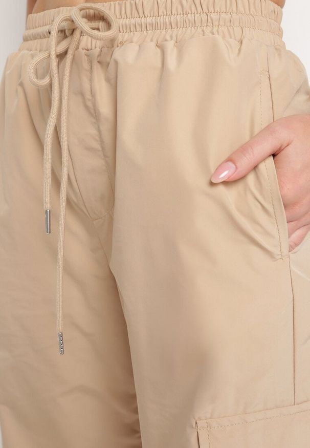 Born2be - Beżowe Spodnie Typu Bojówki z Gumką w Pasie z Kieszeniami i Ściągaczami Lomienna. Kolor: beżowy