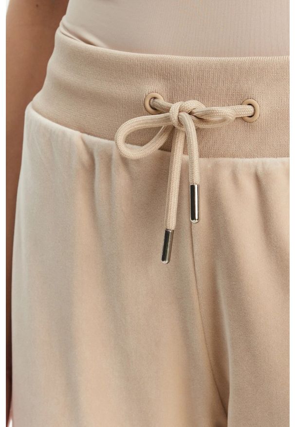 Guess - GUESS Beżowe damskie spodnie dresowe Couture, Rozmiar XS. Kolor: beżowy. Materiał: dresówka