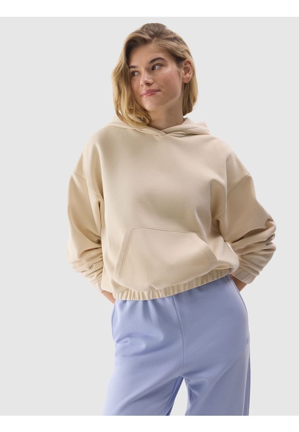 4f - Bluza dresowa nierozpinana z kapturem damska - beżowa. Okazja: na co dzień. Typ kołnierza: kaptur. Kolor: beżowy. Materiał: dresówka, bawełna. Wzór: gładki, ze splotem. Styl: sportowy, casual